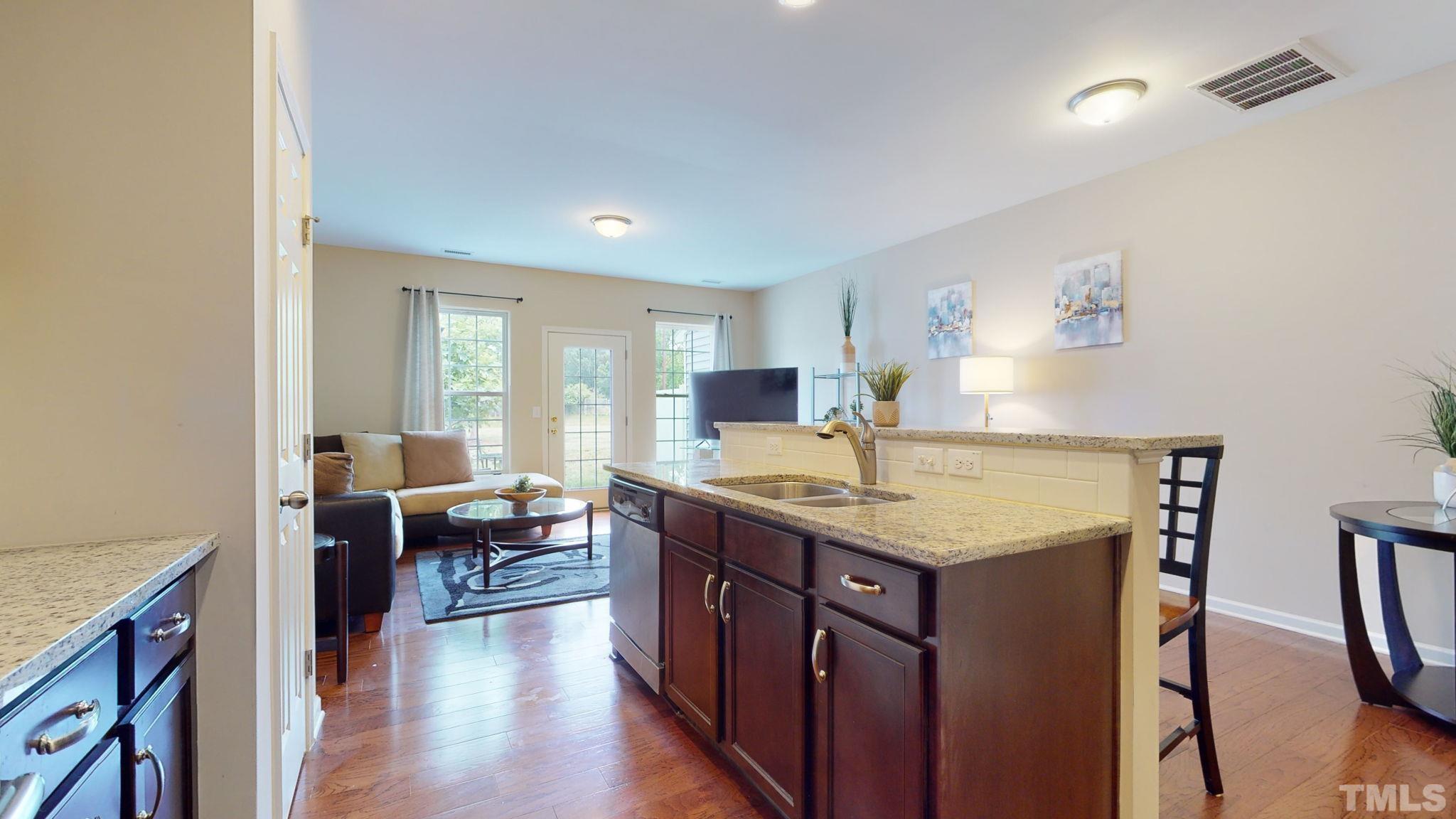 944 Consortium Drive Raleigh, NC 27603 - Photo 15 of 30 a kitchen with a stove a sink a refrigerator and chairs