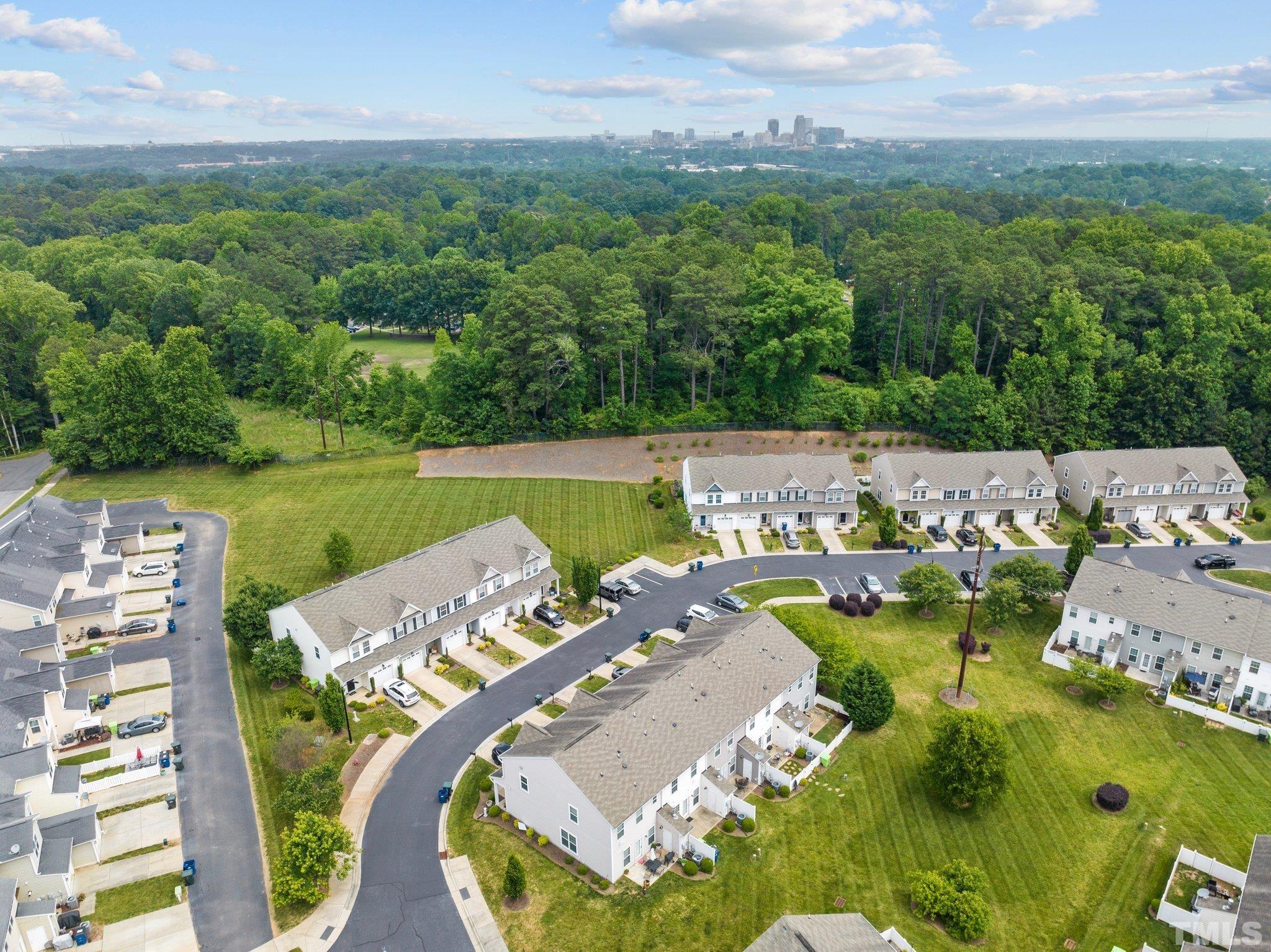 944 Consortium Drive Raleigh, NC 27603 - Photo 4 of 30 an aerial view of a swimming pool with lawn chairs and large trees