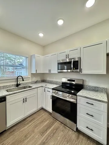 a kitchen with stainless steel appliances a refrigerator stove and microwave