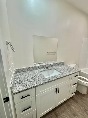 a bathroom with a granite countertop sink and a mirror