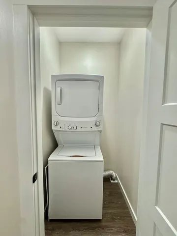 an empty room with wooden floor chandelier fan and windows