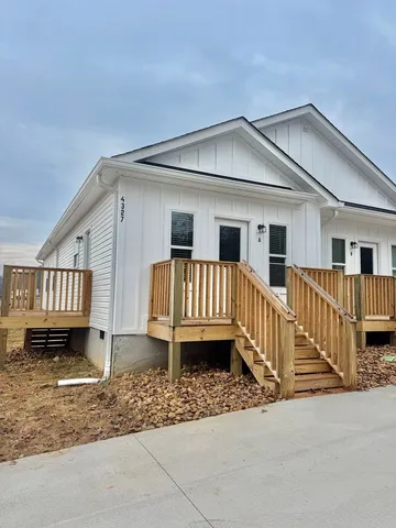 a view of a house with wooden deck front of house