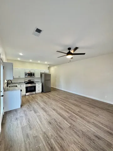 a view of a livingroom with wooden floor and a ceiling fan