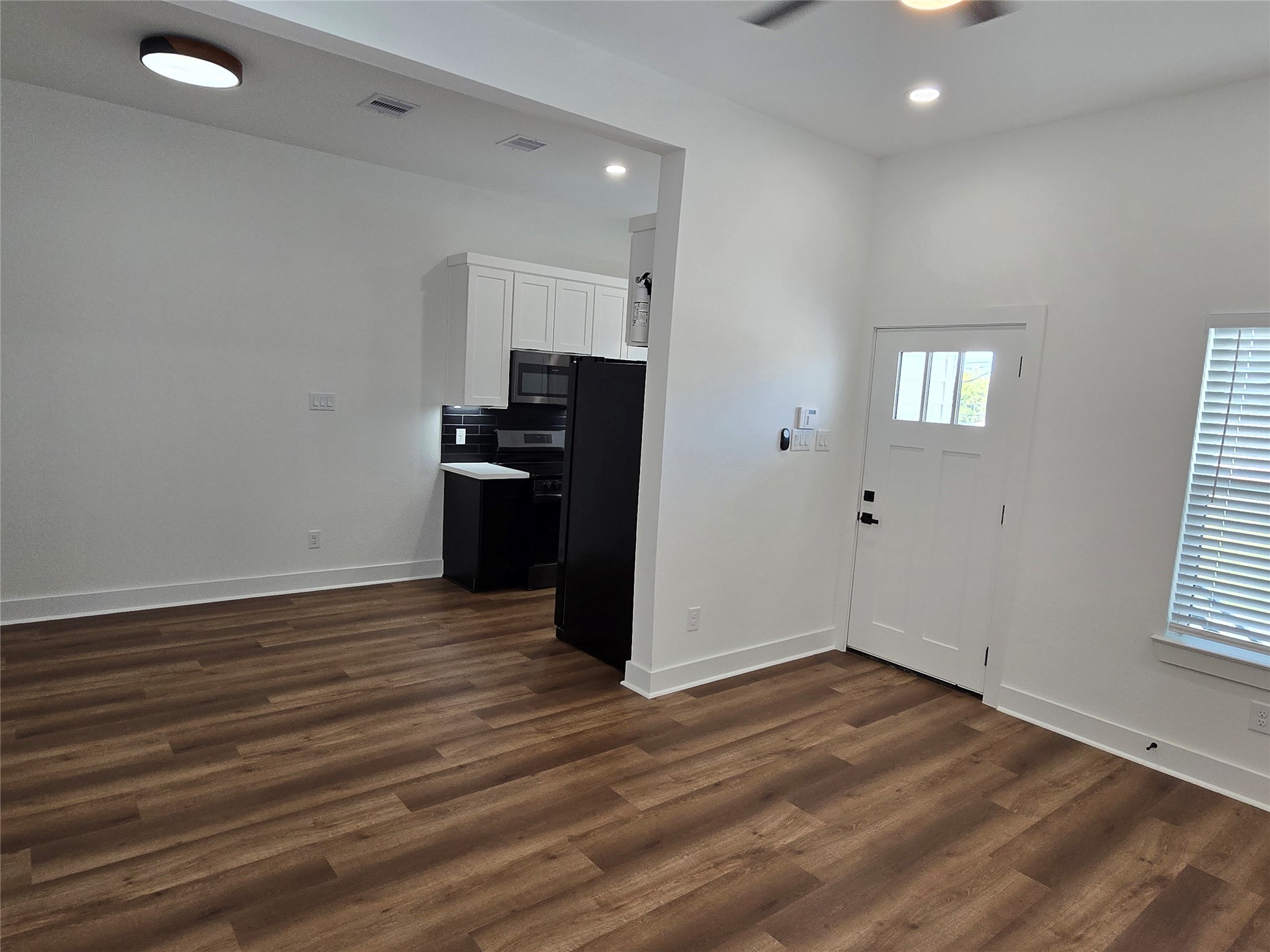 9808 Pelsey Street, Unit B Houston, TX 77029 - Photo 2 of 17 an empty room with wooden floor and windows