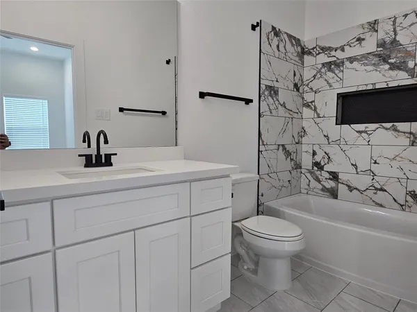 a bathroom with a sink toilet vanity and shower