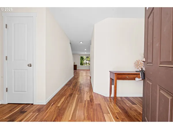 a view of a hallway with wooden floor and staircase