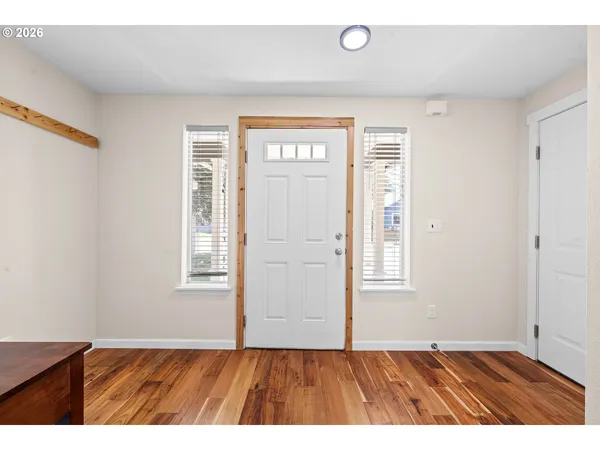 an empty room with wooden floor and windows