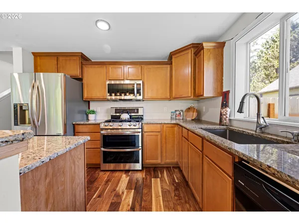 a kitchen with stainless steel appliances granite countertop a sink stove and refrigerator