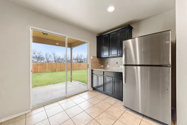 a kitchen with a refrigerator a sink and a view of living room