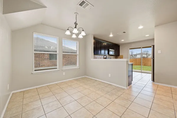 a view of a livingroom with a chandelier furniture and windows