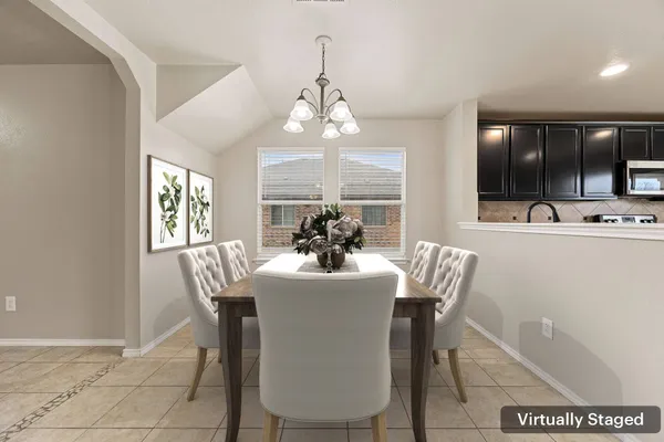 a dining room with furniture a chandelier and window