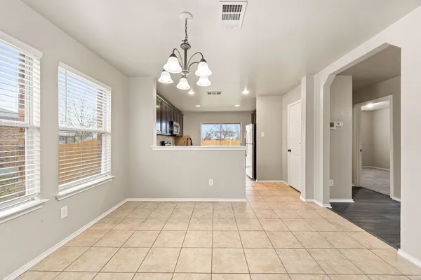 a view of a livingroom with a chandelier fan and windows