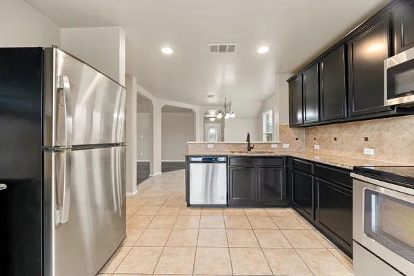 a kitchen with stainless steel appliances granite countertop a refrigerator and a sink