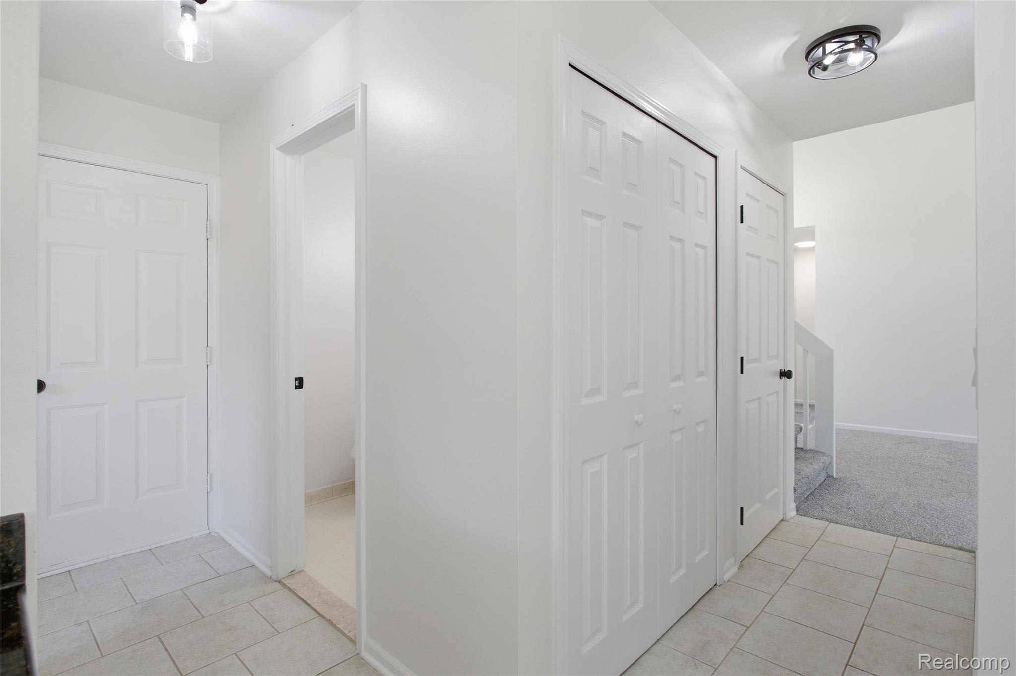 52658 Stag Ridge Drive Macomb, MI 48042 - Photo 13 of 28 Entryway featuring light-toned tile flooring, white six-panel doors, and a modern flush-mount ceiling light fixture