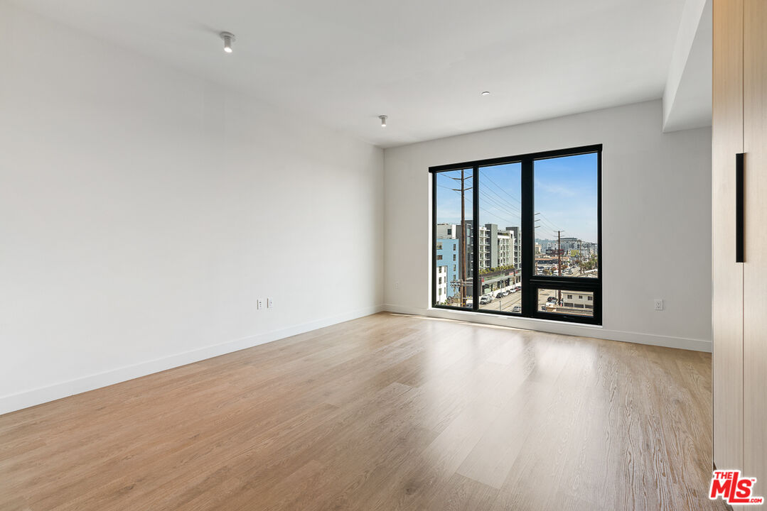 10700 Tabor Street, Unit 204 Los Angeles, CA 90034 - Photo 2 of 25 a view of an empty room with wooden floor and a window