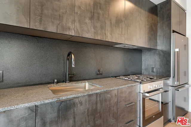 a room with granite countertop a sink a stove and cabinets