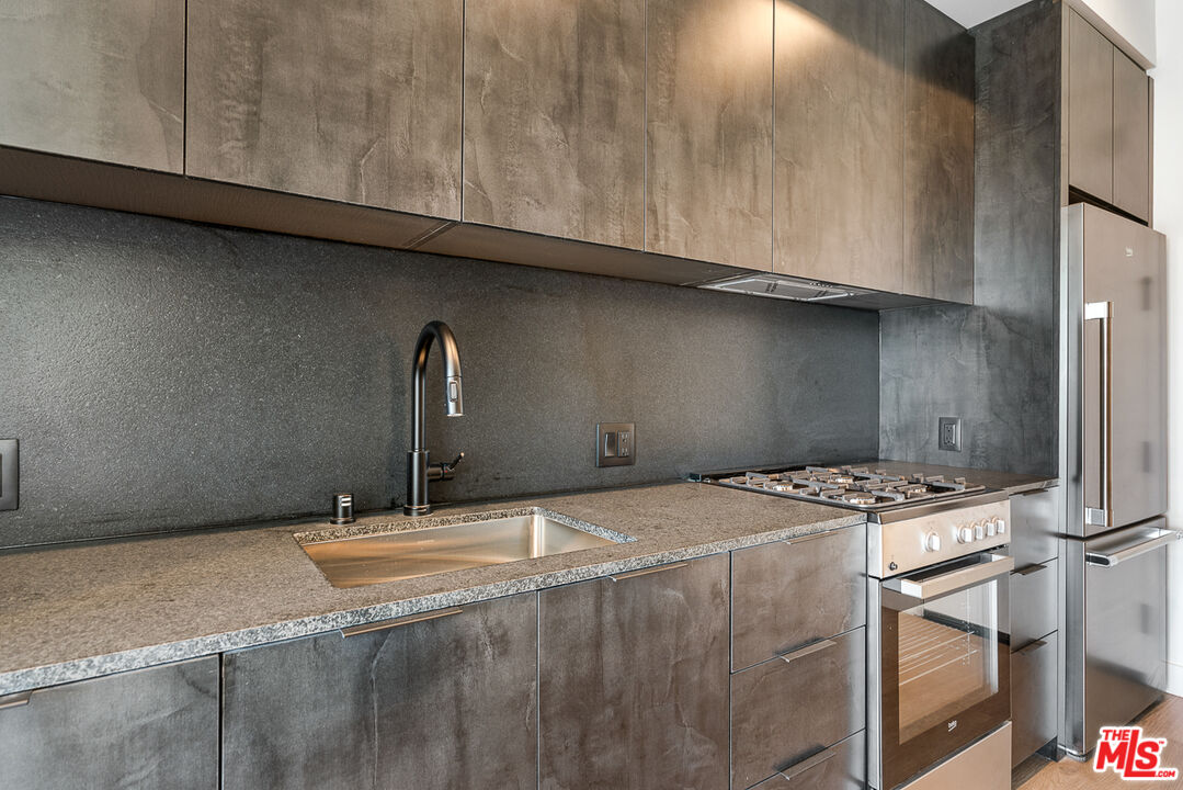 10700 Tabor Street, Unit 204 Los Angeles, CA 90034 - Photo 5 of 25 a room with granite countertop a sink a stove and cabinets
