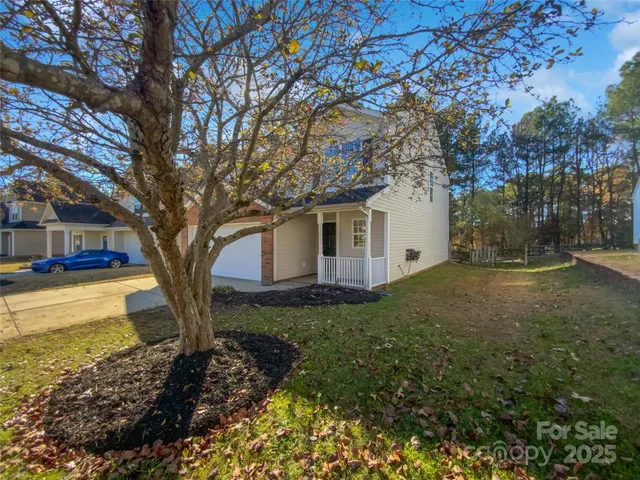 a view of a house with backyard and trees