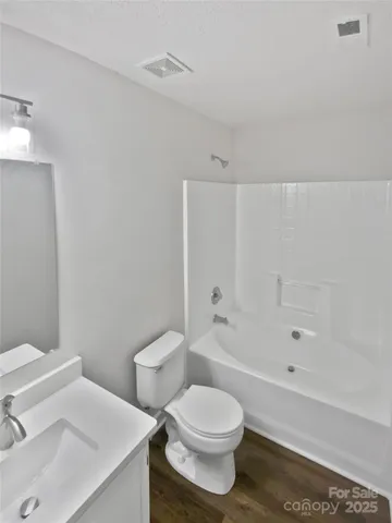 a white toilet sitting next to a bath tub