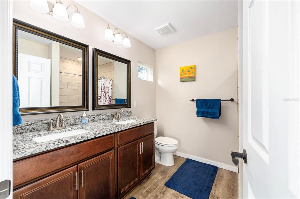 13057 Southwest 85th Circle Ocala, FL 34473 - Photo 13 of 34 a bathroom with a granite countertop sink mirror vanity and a toilet