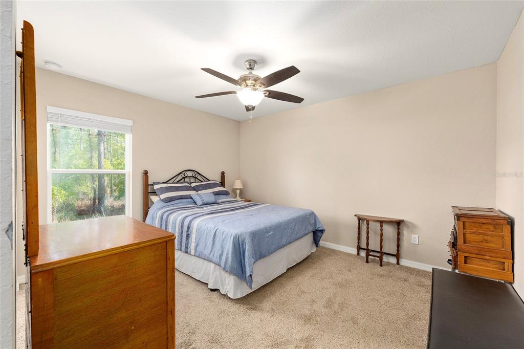 13057 Southwest 85th Circle Ocala, FL 34473 - Photo 18 of 34 a bedroom with a bed and a chandelier