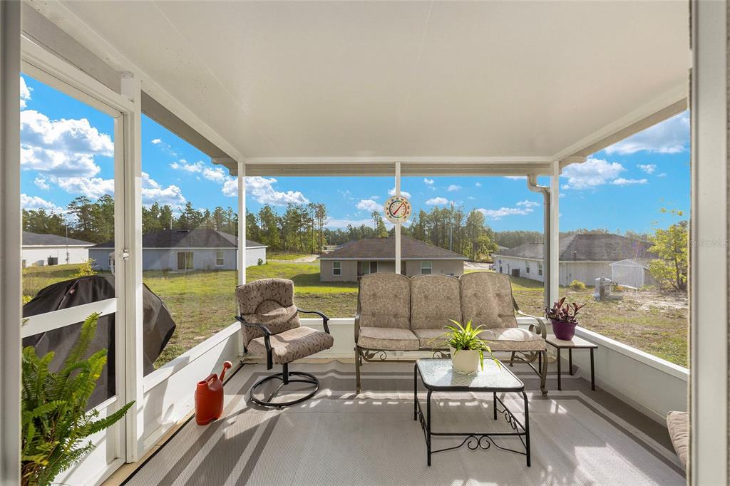 13057 Southwest 85th Circle Ocala, FL 34473 - Photo 20 of 34 a view of a balcony with chairs and floor to ceiling window next to a yard