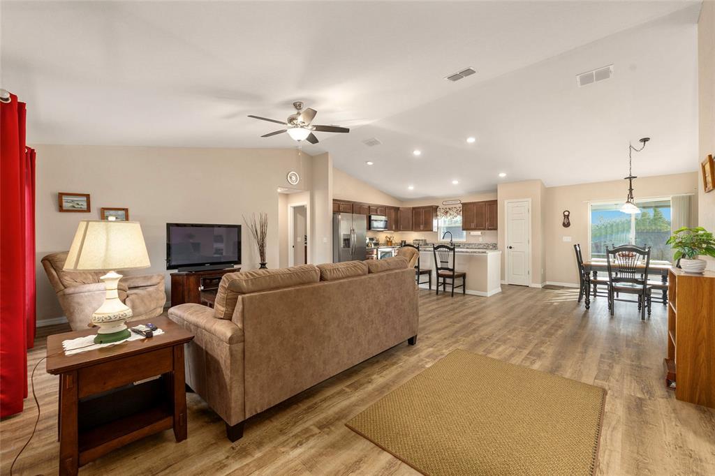 13057 Southwest 85th Circle Ocala, FL 34473 - Photo 2 of 34 a living room with furniture a fireplace and a flat screen tv
