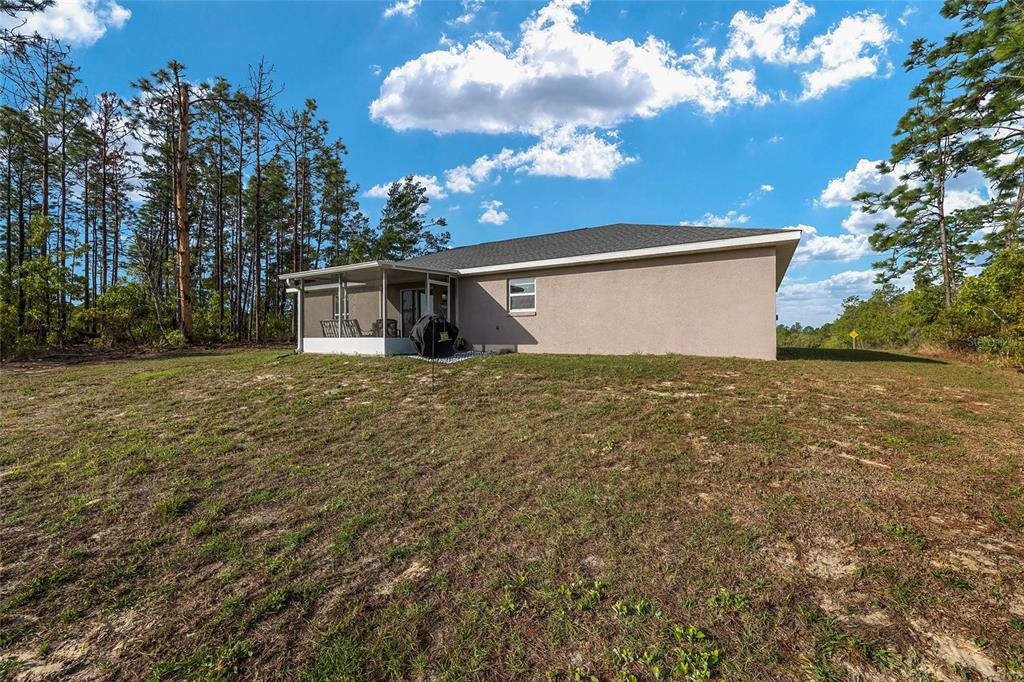 13057 Southwest 85th Circle Ocala, FL 34473 - Photo 24 of 34 a view of a backyard with potted plants and large trees