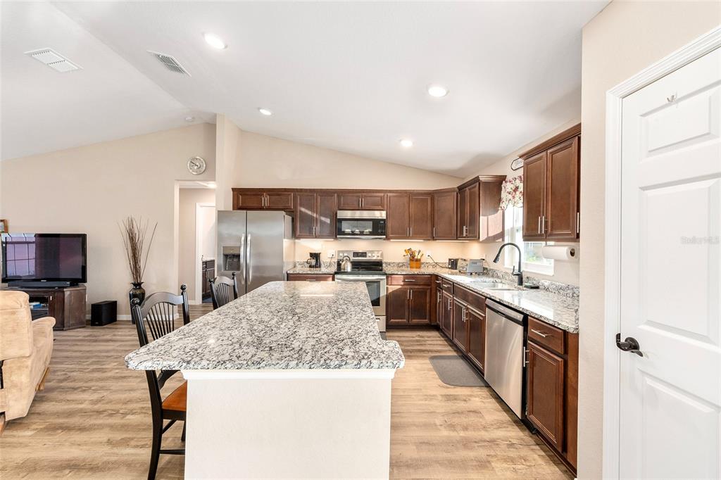 13057 Southwest 85th Circle Ocala, FL 34473 - Photo 8 of 34 a large kitchen with kitchen island a sink stove and refrigerator