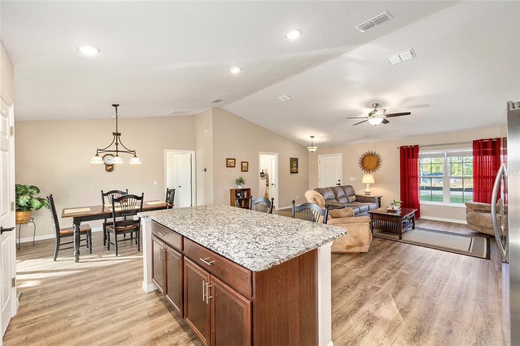 13057 Southwest 85th Circle Ocala, FL 34473 - Photo 9 of 34 an open kitchen with kitchen island a sink table and chairs