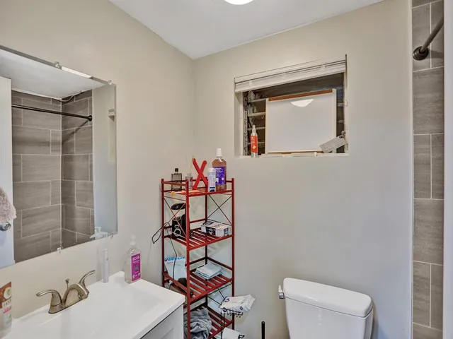 a bathroom with a toilet sink vanity and mirror