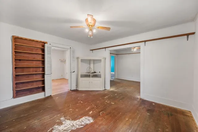 a view of empty room with refrigerator and ceiling fan