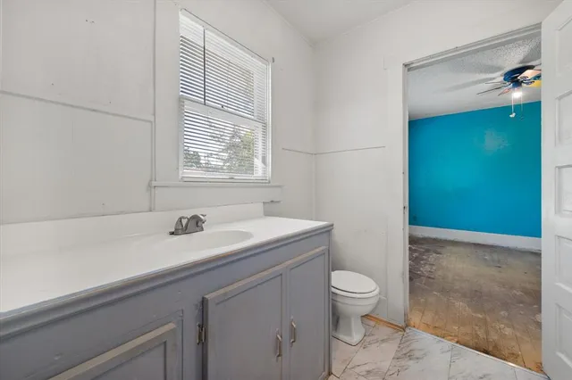 a bathroom with a sink a toilet and a mirror