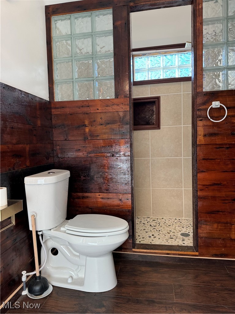 9529 Ashland Road Wooster, OH 44691 - Photo 11 of 24 Bathroom with a shower, wood walls, toilet, and hardwood / wood-style flooring