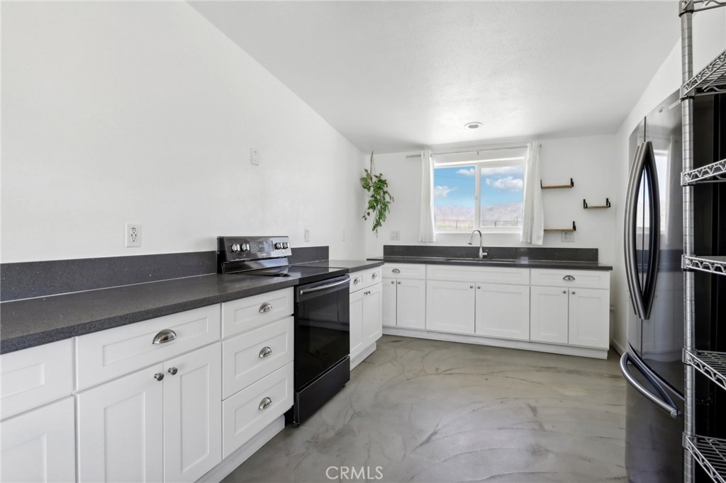51474 Mills Road Johnson Valley, CA 92285 - Photo 15 of 56 a kitchen with granite countertop white cabinets and stainless steel appliances