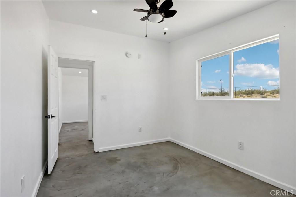 51474 Mills Road Johnson Valley, CA 92285 - Photo 22 of 56 an empty room with a window and a ceiling fan
