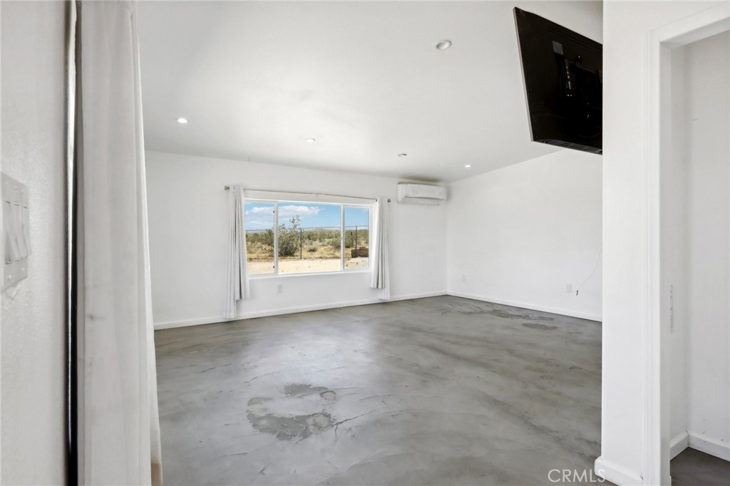 51474 Mills Road Johnson Valley, CA 92285 - Photo 23 of 56 an empty room with kitchen view and wooden floor
