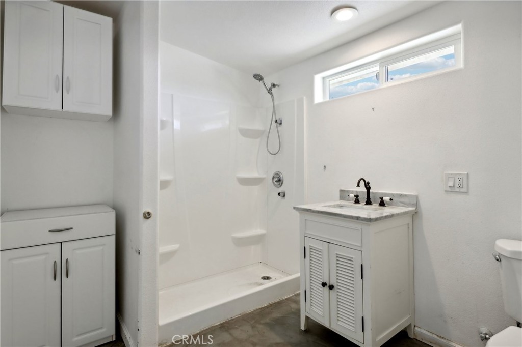 51474 Mills Road Johnson Valley, CA 92285 - Photo 25 of 56 a bathroom with a granite countertop sink a toilet and shower
