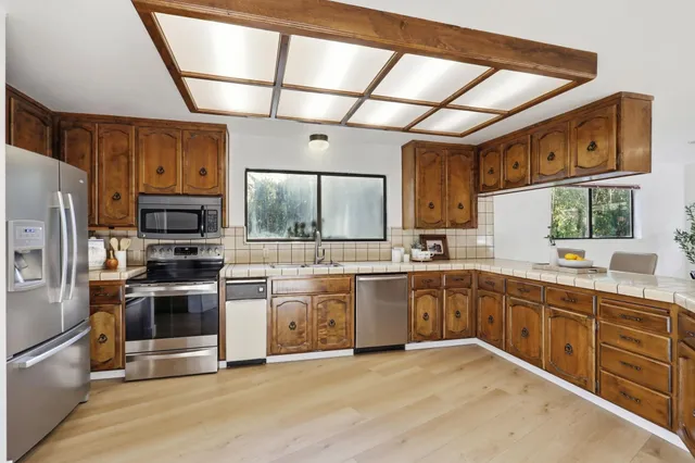 a kitchen with stainless steel appliances a refrigerator and a sink