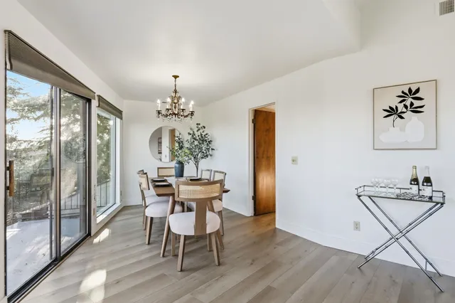 a dining room with furniture potted plants and wooden floor