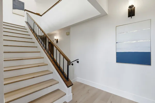 a spacious bedroom with a bed and a painting on the wall