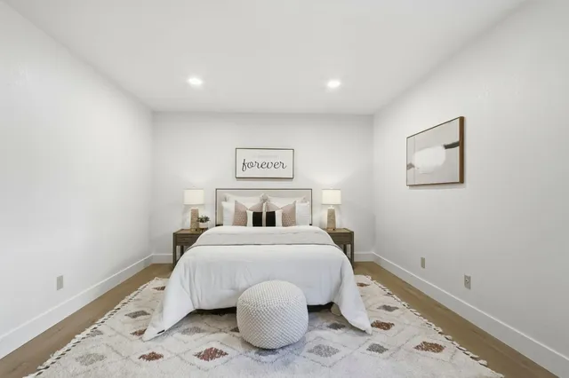 a bedroom with a bed and a painting on the wall