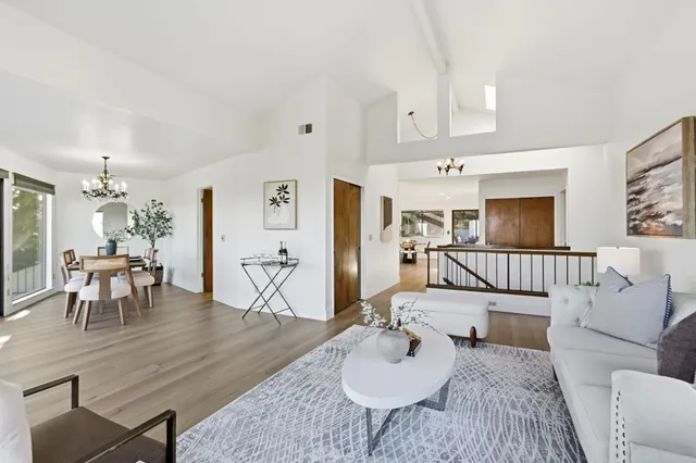 a living room with furniture a fireplace and a floor to ceiling window