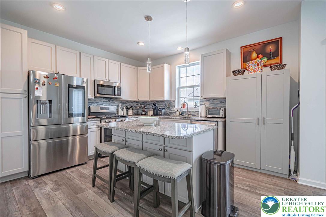 4435 Stole Road Emmaus, PA 18049 - Photo 15 of 64 a kitchen with stainless steel appliances granite countertop a refrigerator a stove a sink a dining table and chairs with wooden floor