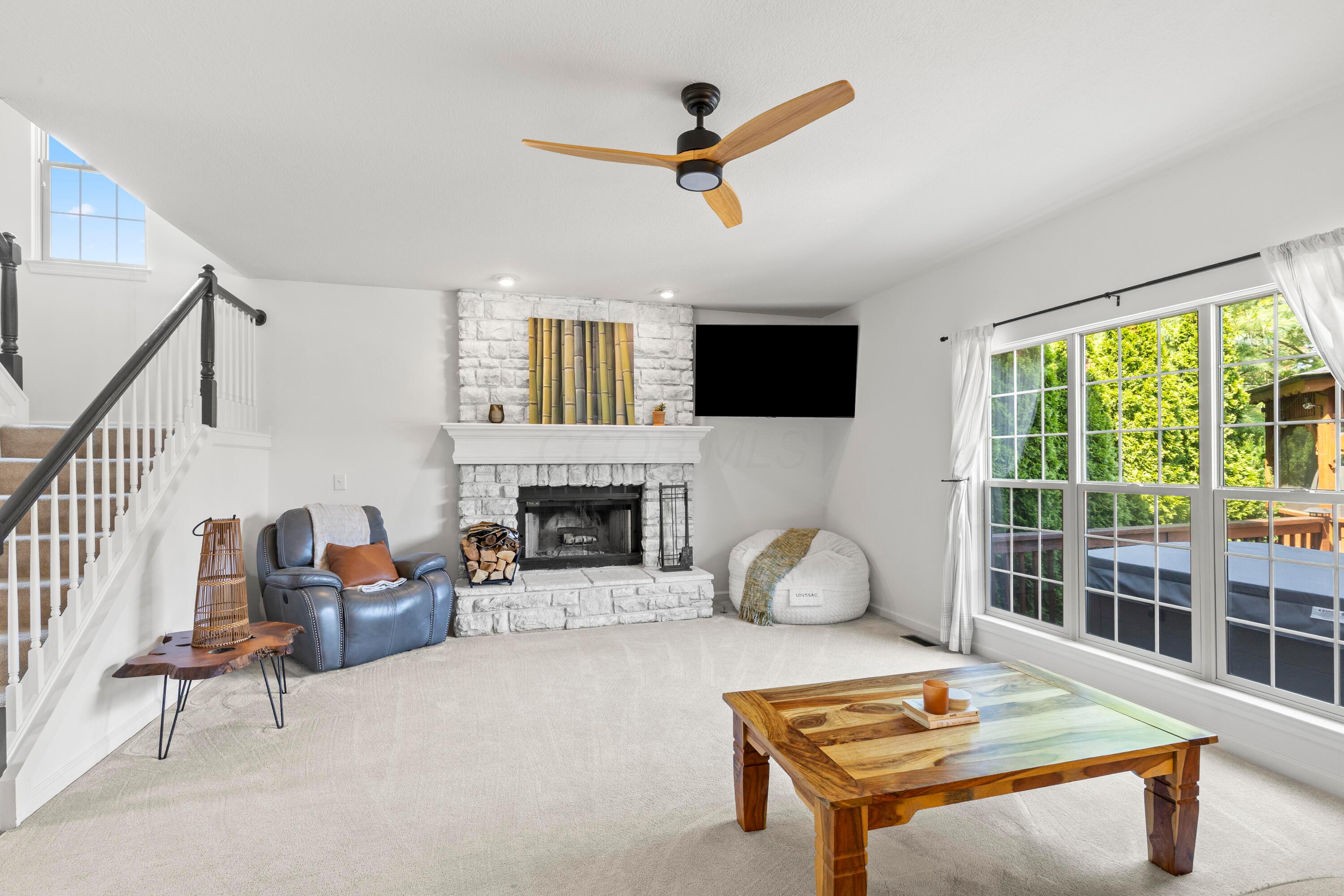 1515 Dale Ford Road Delaware, OH 43015 - Photo 16 of 74 • Light sand carpet • Ivory painted walls • New lighted ceiling fan ~ 2023 • Woodburning stone fireplace with gas starter, mantle & raised hearth • TV does not remain • Mount remains