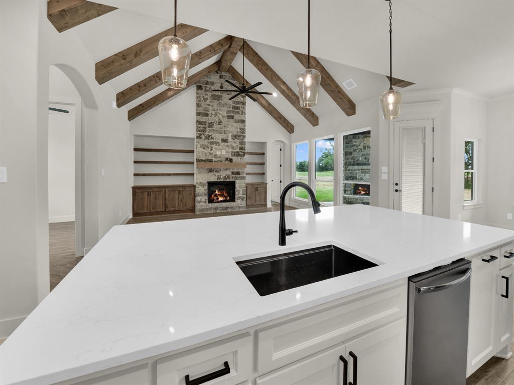 305 Wrangler Court Weatherford, TX 76088 - Photo 13 of 32 a kitchen with stainless steel appliances a sink a faucet a stove and white cabinets