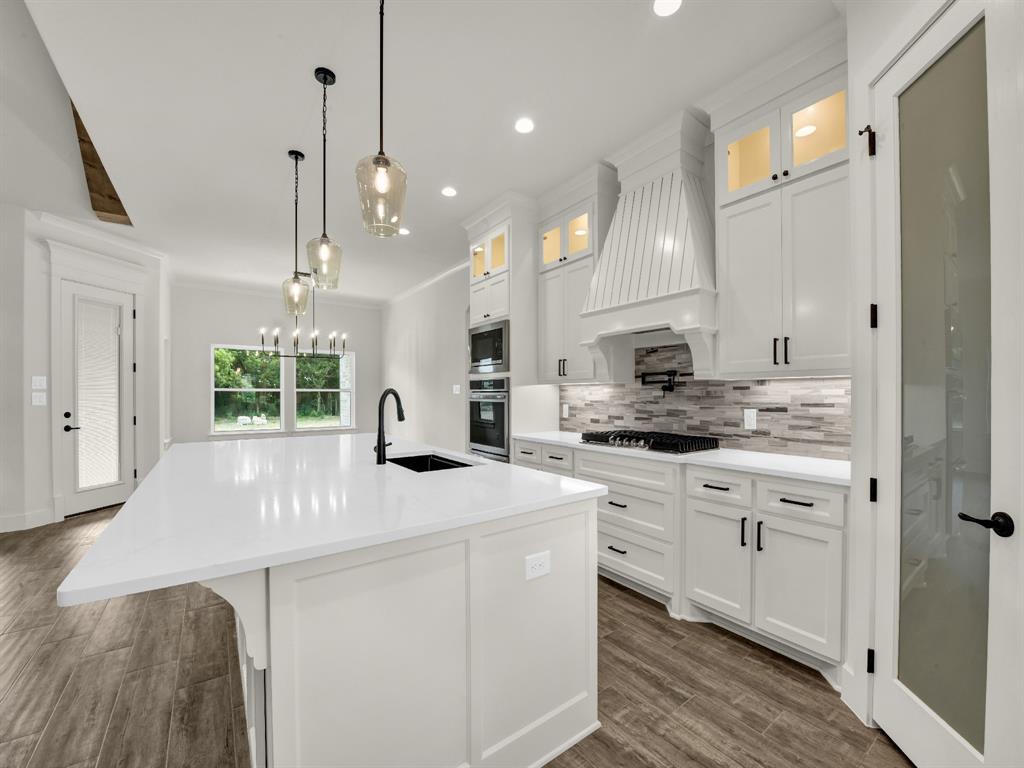 305 Wrangler Court Weatherford, TX 76088 - Photo 14 of 32 a kitchen with kitchen island white cabinets and white appliances