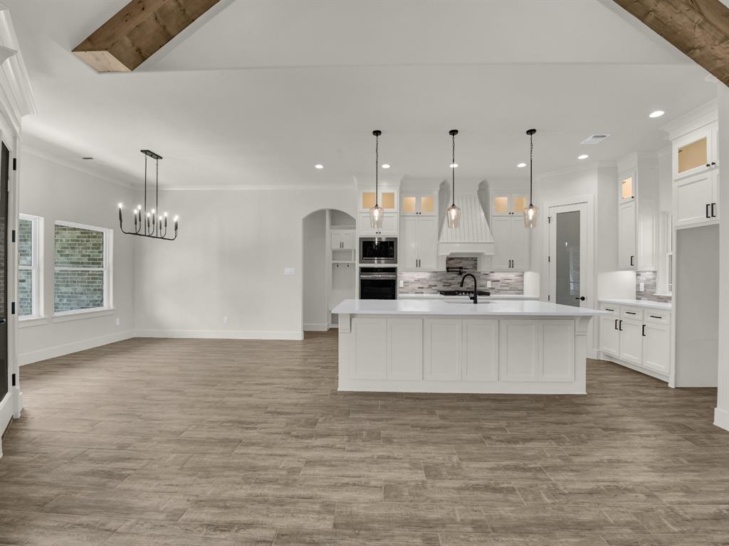 305 Wrangler Court Weatherford, TX 76088 - Photo 17 of 32 a large kitchen with stainless steel appliances kitchen island a large counter top and wooden floors