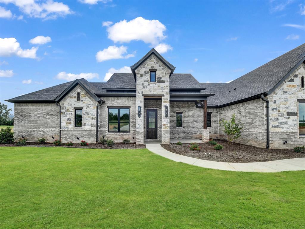 305 Wrangler Court Weatherford, TX 76088 - Photo 2 of 32 a front view of a house with a yard and garage