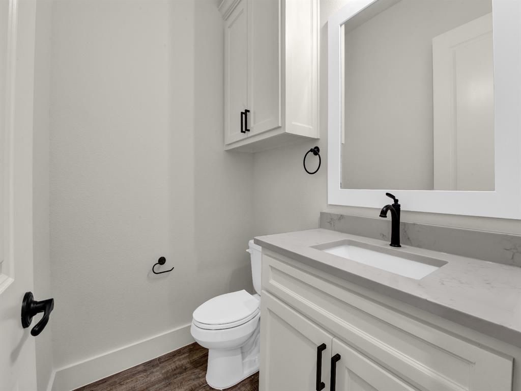 305 Wrangler Court Weatherford, TX 76088 - Photo 30 of 32 a bathroom with a sink a toilet and mirror